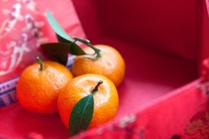 Mini mandarin oranges in a red chinese box with new  year money packet