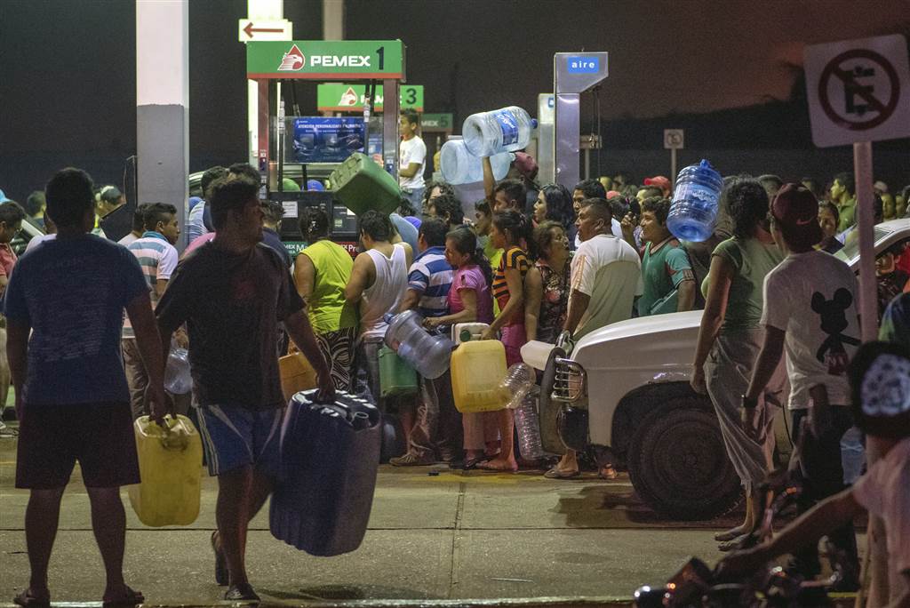 Residents steal gasoline and diesel from a gas station following protests against an increase in fuel prices in Allende, southern Veracuz State, Mexico, late on Jan. 3. Photo Source: Erick Herrera / AP